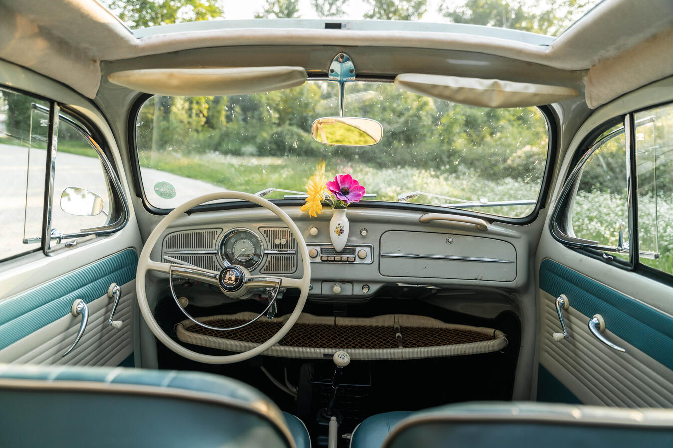Fahrer und Beifahrer im VW Käfer Baujahr 1960